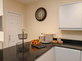 A kitchen with a clock and a basket on the counter at Hazelgarth House in Hunmanby