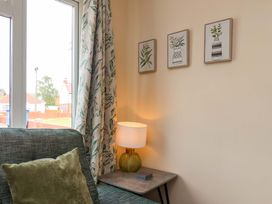 A living room with a sofa and lamp at Hazelgarth House in Hunmanby