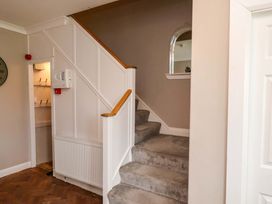 A staircase and wall with clock in a hallway at Hazelgarth House in Hunmanby
