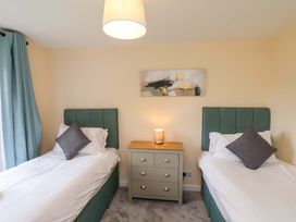 A bedroom with two beds and a nightstand at Hazelgarth House in Hunmanby
