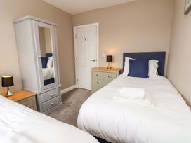A bedroom with two single beds and a wardrobe at Hazelgarth House in Hunmanby