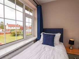 A bedroom with a bed and window at Hazelgarth House in Hunmanby