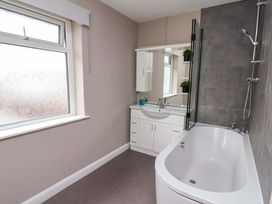 A bathroom with a bathtub and sink at Hazelgarth House in Hunmanby