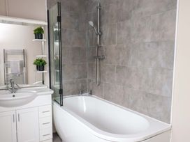 A bathroom with a bathtub and sink at Hazelgarth House in Hunmanby