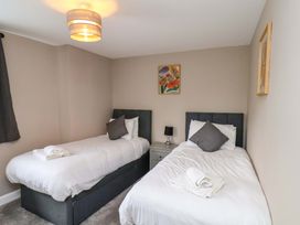 A bedroom with two beds and a nightstand at Hazelgarth House in Hunmanby