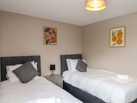 A bedroom with two single beds and wall art at Hazelgarth House Hunmanby