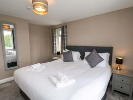 A bedroom with a large bed and mirror at Hazelgarth House in Hunmanby