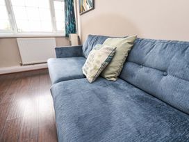 A sofa with cushions near a window at Hazelgarth House Hunmanby