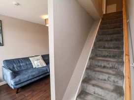 A living room with a sofa and staircase at Hazelgarth House in Hunmanby