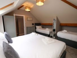 A bedroom with three beds and a dresser at Hazelgarth House in Hunmanby