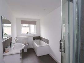 A bathroom with a bath tub and a sink at Hazelgarth House in Hunmanby