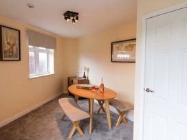 A dining room with a round table and benches at Hazelgarth House Hunmanby