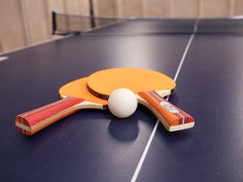Ping pong paddles and a ball on a table at Hazelgarth House in Hunmanby