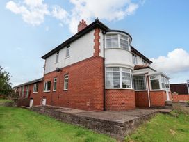 A house with a brick exterior and patio at Hazelgarth House in Hunmanby