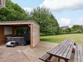 A wooden shelter with a hot tub in the garden of Hazelgarth House, Hunmanby