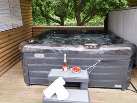 A hot tub with steps and a wine bottle at Hazelgarth House Hunmanby
