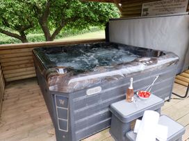 A hot tub with a side table holding wine and strawberries at Hazelgarth House in Hunmanby