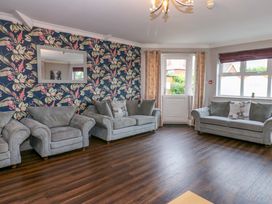 A living room with sofas and a mirror at Fern Lee in Carlisle