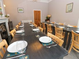 A dining room with a long table set for a meal at Fern Lee in Carlisle