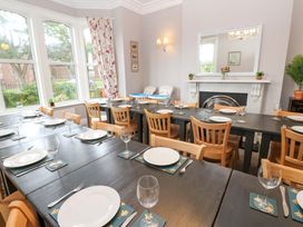 A dining room with a long table set for a meal at Fern Lee in Carlisle