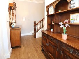 A hallway with a cabinet and staircase at Fern Lee in Carlisle