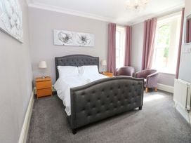 A bedroom with a bed and chairs at Fern Lee in Carlisle
