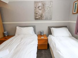 A bedroom with two single beds and a wall art at Fern Lee, Carlisle