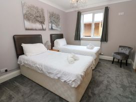 A bedroom with twin beds and a chair at Fern Lee in Carlisle