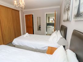 A bedroom with two single beds and a wardrobe at Fern Lee in Carlisle