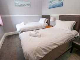A bedroom with two beds and a lamp on a nightstand at Fern Lee in Carlisle