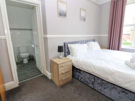 A bedroom with a bed and adjoining bathroom at Fern Lee in Carlisle
