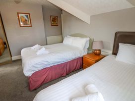 A bedroom with two beds and a bedside table at Fern Lee in Carlisle