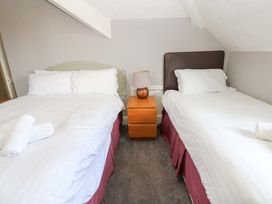 A bedroom with two beds and a bedside table at Fern Lee in Carlisle