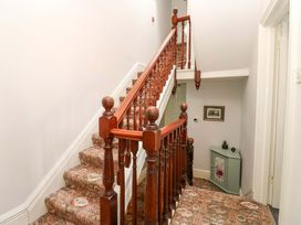 A staircase with a carpet and a cabinet at Fern Lee in Carlisle
