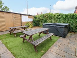 A garden area with a picnic table and hot tub at Fern Lee in Carlisle