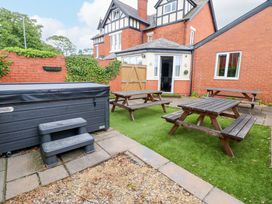 A garden with a hot tub and picnic tables at Fern Lee in Carlisle