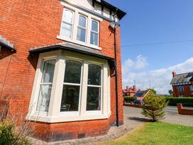 A corner of a red brick house with bay windows and a pathway at Fern Lee in Carlisle