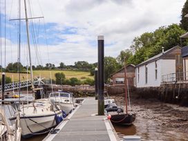 A dock with boats moored along the water at Dolphin Cottage in Brixham