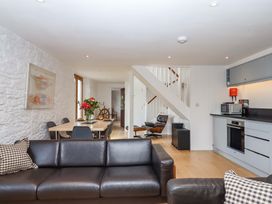 A living room with a sofa, table, and chairs at Dolphin Cottage in Brixham