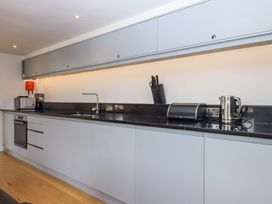 A kitchen with modern appliances and cabinetry at Dolphin Cottage in Brixham