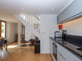 A kitchen with appliances and a staircase at Dolphin Cottage in Brixham