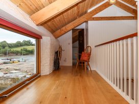 A hallway with a chair and window at Dolphin Cottage in Brixham