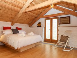 A bedroom with a bed and rocking chair at Dolphin Cottage in Brixham