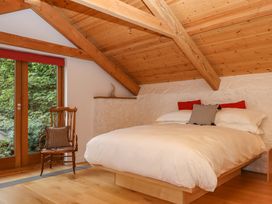 A bedroom with a bed and chair at Dolphin Cottage in Brixham