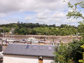 A view of boats on water with trees and a building roof at Dolphin Cottage in Brixham