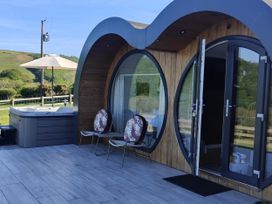 An outdoor area with a hot tub and chairs at Ceunant in Llanfihangel-y-Creuddyn near Aberystwyth