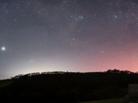 A night sky with stars and a silhouette of hills at Ceunant in Llanfihangel-y-Creuddyn near Aberystwyth