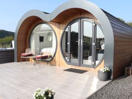 An outdoor area featuring chairs and a circular window at Ceunant in Llanfihangel-y-Creuddyn near Aberystwyth