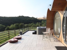 An outdoor area with a hot tub and deck chairs at Ceunant in Llanfihangel-y-Creuddyn near Aberystwyth