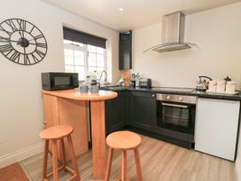 A kitchen with a bar and stools at Well Cottage Nr Malmesbury
